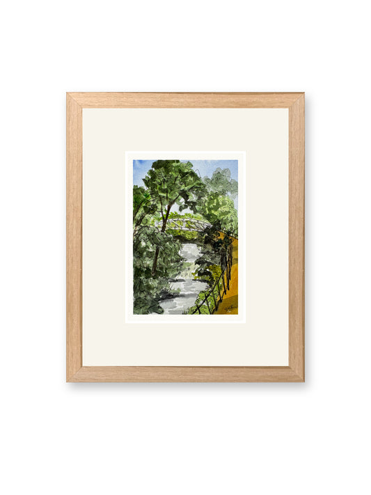 Footbridge over summer stream, line and watercolor painting shown in its frame